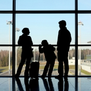 Silhouette of family with luggage standing near window Planning a trip abroad