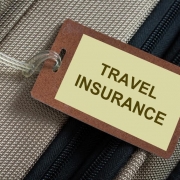 Travel insurance tag tied to a luggage travel insurance plans